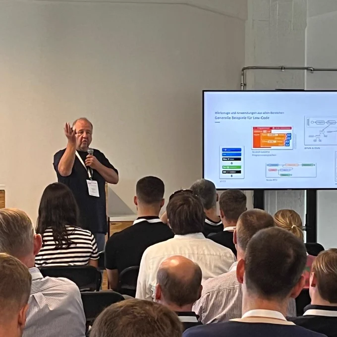 Jan Gottschick, Fraunhofer FOKUS, stellt dem Publikum des Low Code Day 2024 anhand einer Präsentation den Low-Code-Wegbereiter vor