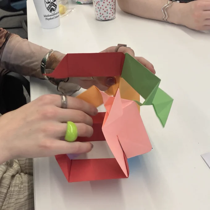Origami pieces (attempted) to be put together to make a cube.