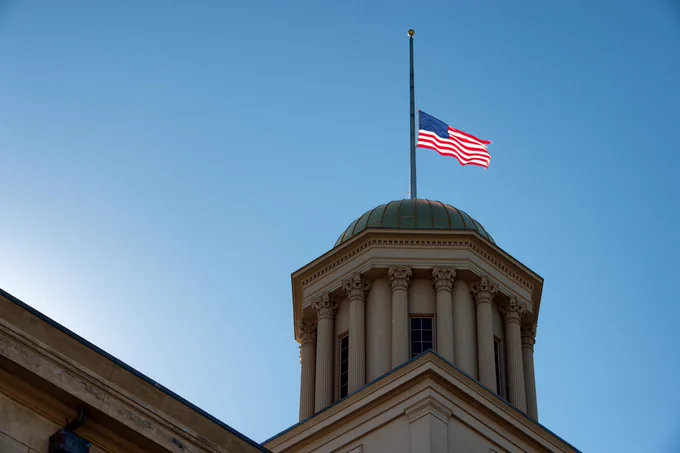 Photo of the United States of America flag half-staff on the Old Capitol Building.