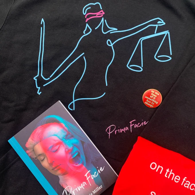 An image that shows a hoodie with a woman holding scales on, a badge that reads 'on the face of it something has to change', a play text of Prima Facie and a red t-shirt.