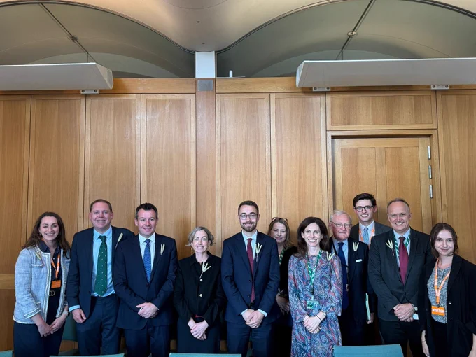 A photo of Luke and other members of the APPG on Food Security smiling behind a table
