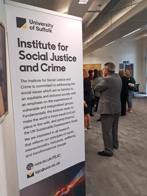 A banner which says 'Institute for Social Justice and Crime' and visible behind are event delegates gathered around and talking in small groups