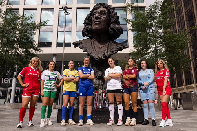 Wrexham’s Erin Lovett, The New Saints’ Maria Francis-Jones, Barry Town United’s Emily Freeman, Cardiff City’s Megan Bowen, Swansea City’s Chloe Chivers, Cardiff Met’s Faith Mulenga, Aberystwyth Town’s Chelsea Herbert and Briton Ferry Llansawel’s Alice Broadley stand in front of the iconic Betty Campbell statue in Cardiff.