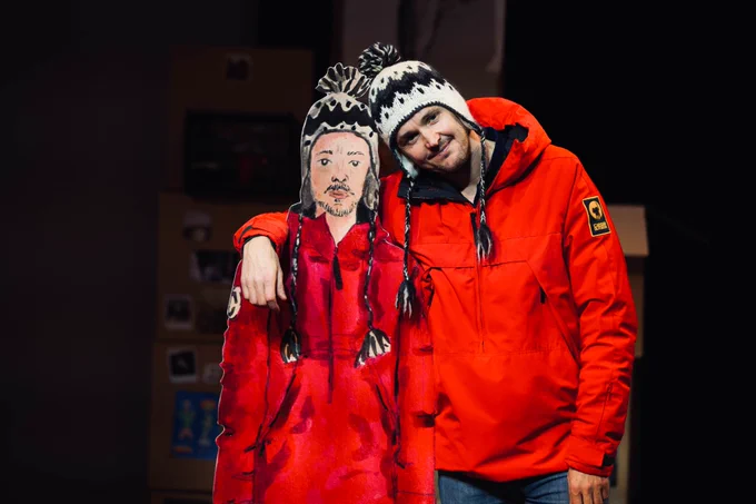 Promotional photo for a A Version of Life: Man in red jacket stands beside cartoon cardboard cutout of man in red jacket