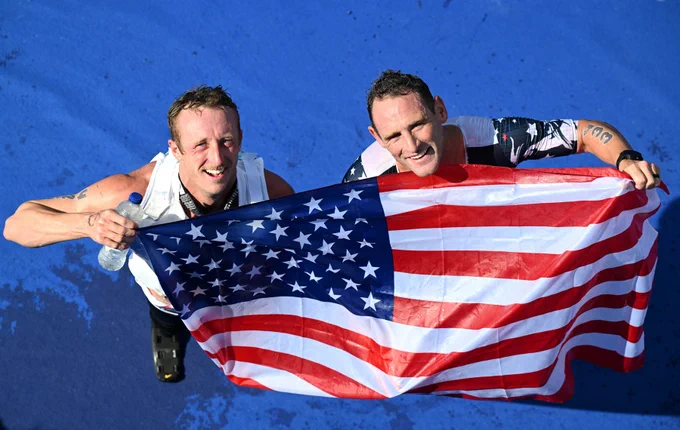Two people holding up an American flag.