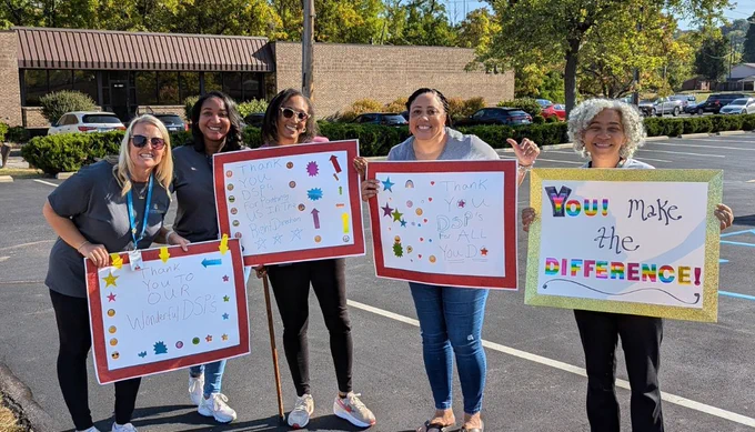 Five people stand outdoors holding colorful thank you signs, expressing gratitude with phrases like "You make the difference" and "Thank you to our wonderful DSPs.