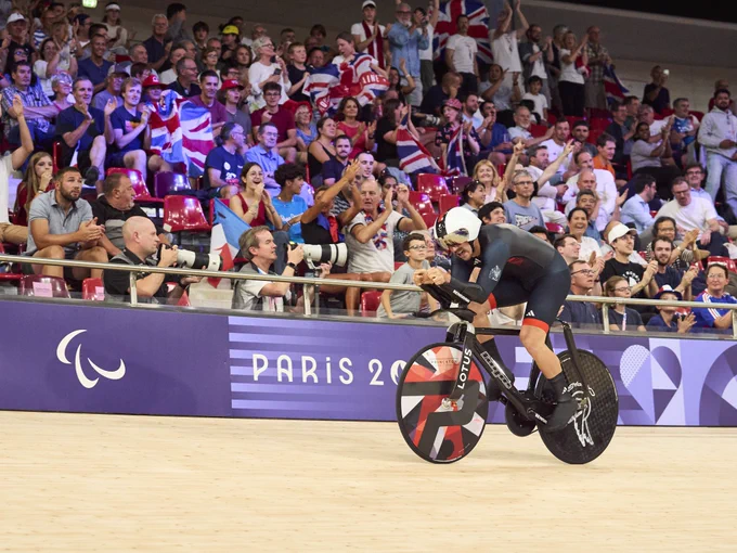 The velodrome full with Union flags on display for Blaine hunt as he cycles past
