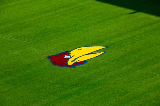 Aerial view of the pitch at Children's Mercy Park featuring the colorful Jayhawks mascot logo of the University of Kansas in the center.