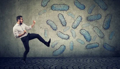 personne habillée en costard, qui fait du kung fu (ou se bat), dans une rue, contre des microbes dessinés sur le mur
