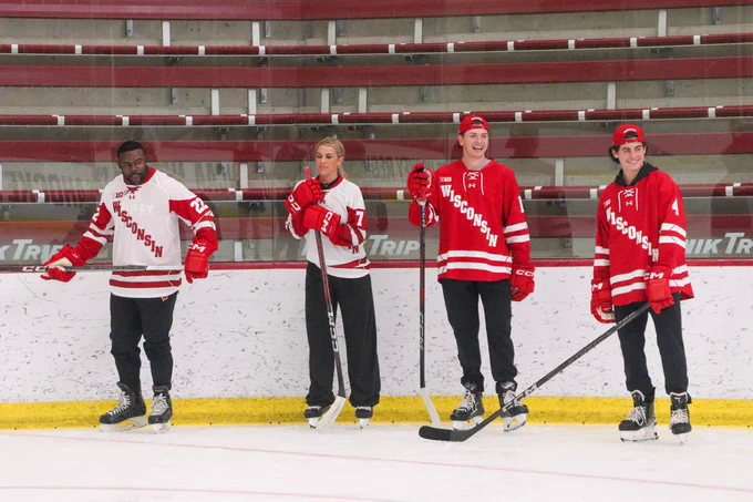 Mark Ingram, Jenny Taft, Christian Fitzgerald, and Ben Dexheimer by the boards in La Bahn arena in red and white Wisconsin jerseys