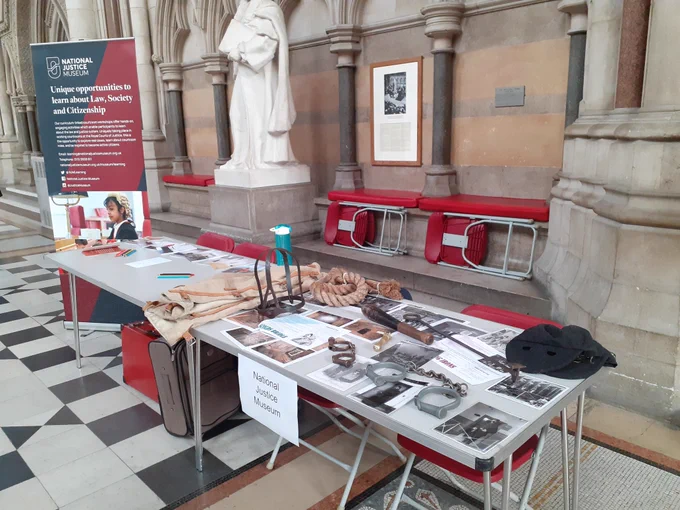 Table of historical items and photos about cime and punishment on a table. 