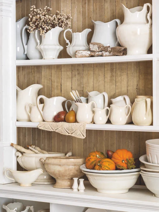 A shelf filled with white ironstone dishware.
