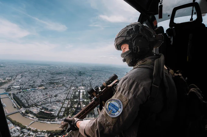 Photographie d'un gendarme du GIGN à bord d'un hélicoptère gendarmerie. Il survole Paris dans le cadre de sa mission de sécurisation.