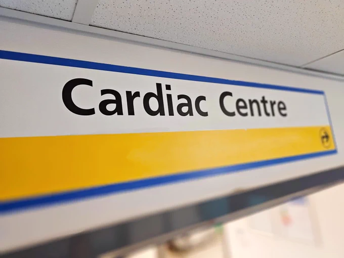 Sign reading "Cardiac Centre" with a yellow stripe, mounted on a wall.