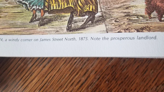 Cropped text from the aforementioned illustration: "...a windy corner on James Street North, 1875. Note the prosperous landlord"