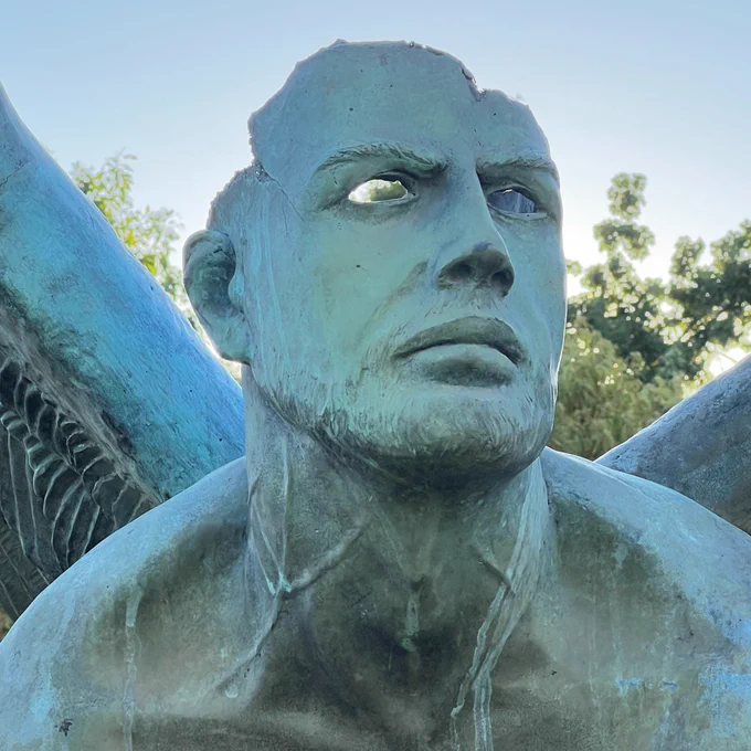 Human-like winged creature with hollow eyes seems to melt.