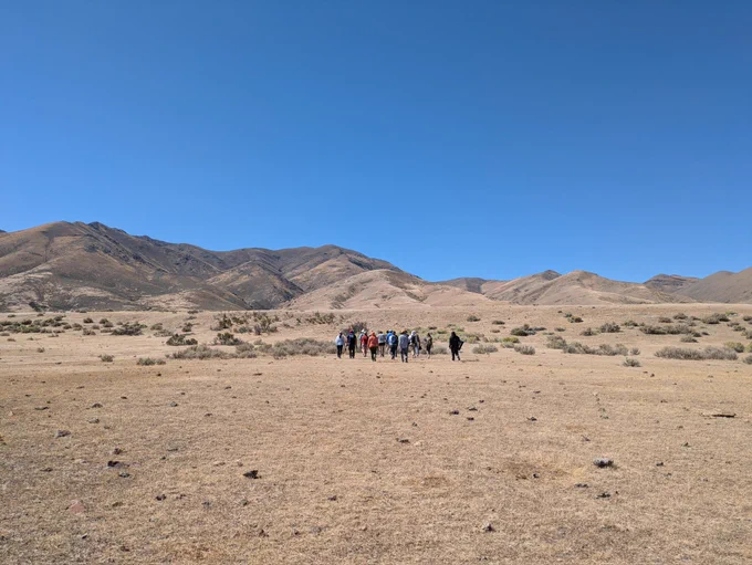 A group of geologists approaching a fault scarp in the desert