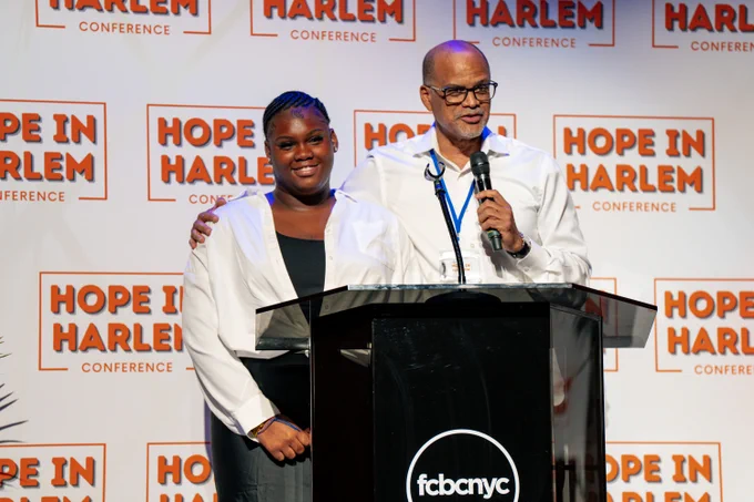 Chancellor Banks on stage at the Hope in Harlem Conference with a student.