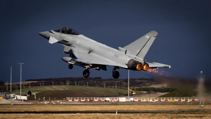 Image shows an RAF Typhoon FGR4 taking off with afterburners glowing.