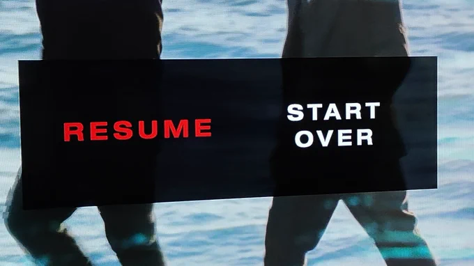 Text on a black background over an image background, one side says Resume in dull red letters the other says Start over in bright white letter 