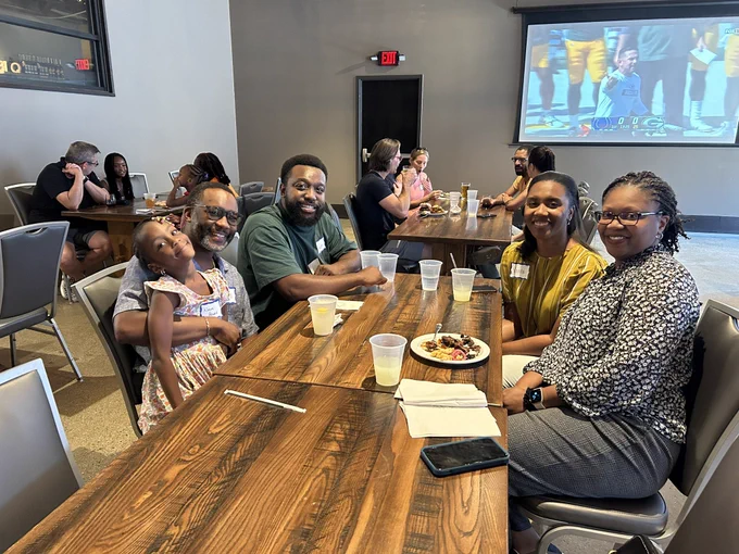 A group of people smile at a table