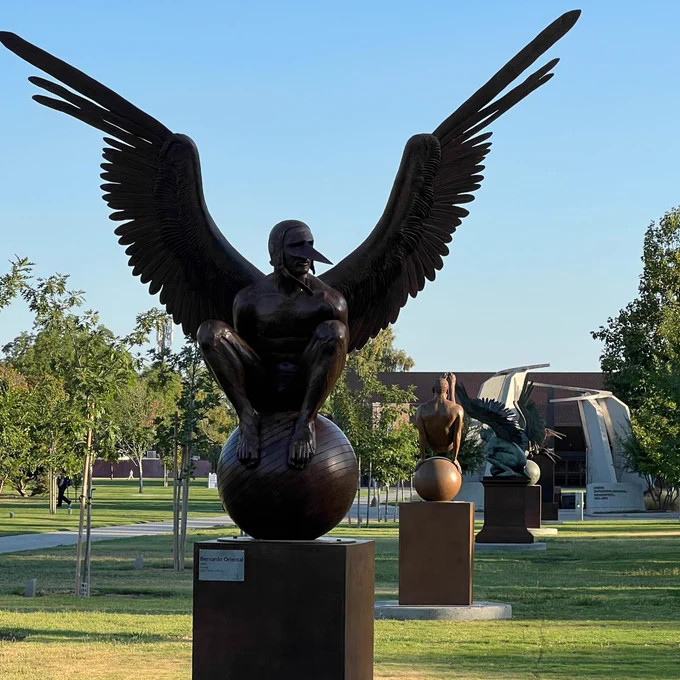 Five bronze winged creature sculptures line the lawn at Fresno State.