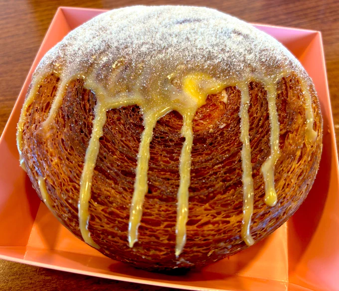 The Mango Coconut Supreme at Mi-Sant in Roseville, a massive circular croissant dripping with mango icing and stuffed with mango-coconut pastry cream.