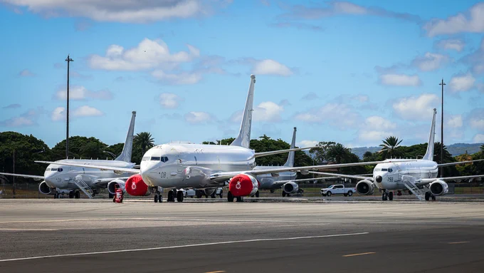 Two RAF Poseidons and a US Navy Poseidon on the ground, from the front.
