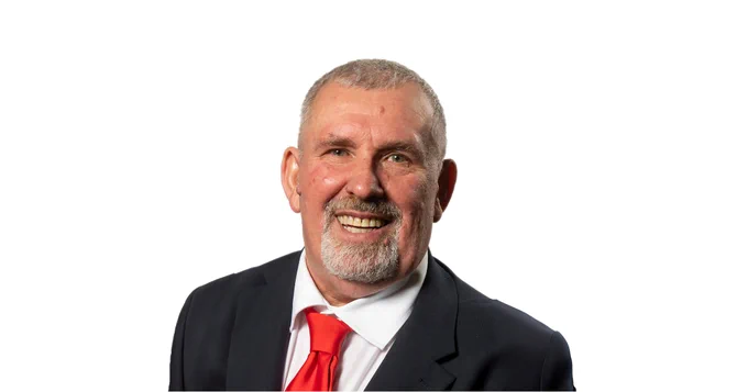 Cllr Paul Wood smiling in front of a white background