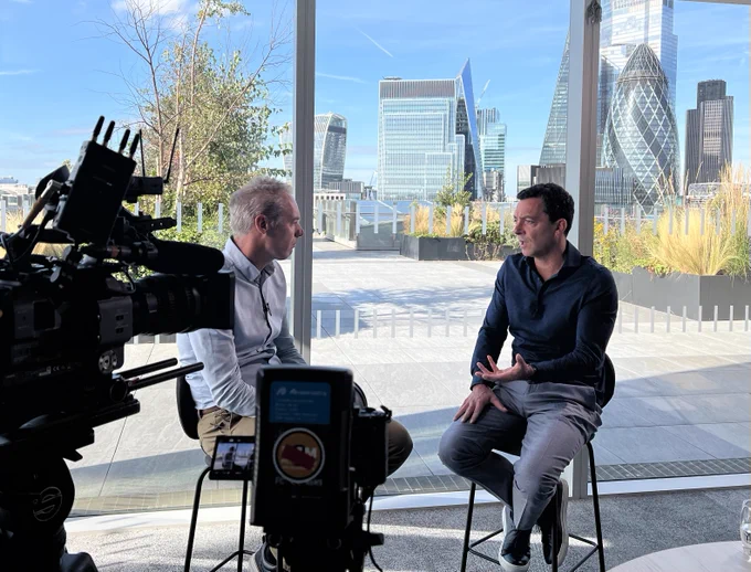 Chatting with CCS Insight's Kester Mann at EE HQ, with cameras in the foreground and a blue-sky view of the City in the background. 