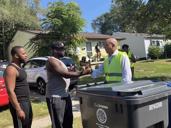Flint Mayor Sheldon Neeley passes out recycling carts to Flint residents.