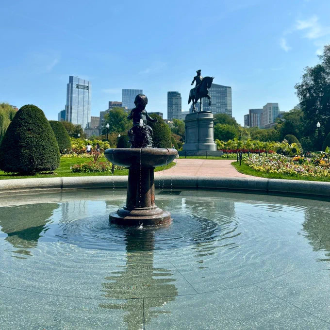 Restored fountain with historic George Washington statue and skyline in the distance. 