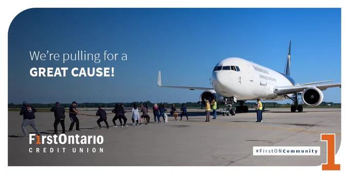 FirstOntario Blue Wave volunteers participating in a plane pull event for a charitable cause, with 'FirstOntario Credit Union' logos and the text 'We're pulling for a GREAT CAUSE!' visible.