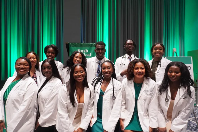 Group of first-year Rush Medical College students in white coats.
