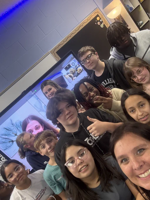 Students standing around an interactive board with Jordyn zooming in.