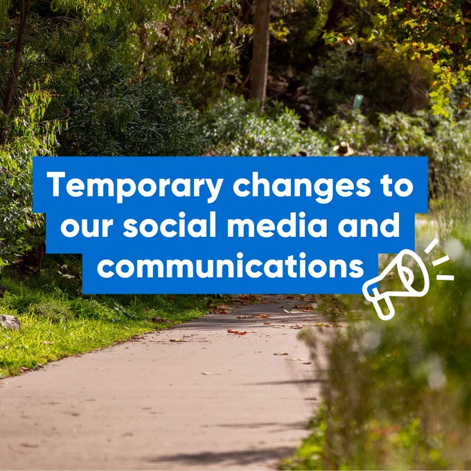 Image showing a pathway through a lush park with a sign announcing 'Temporary changes to our social media and communications', including a graphic of a speech bubble and digital communication icons.