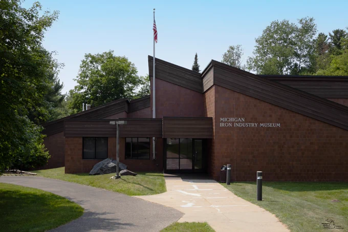 The front of the Michigan Iron Industry Museum, a brown brick building.