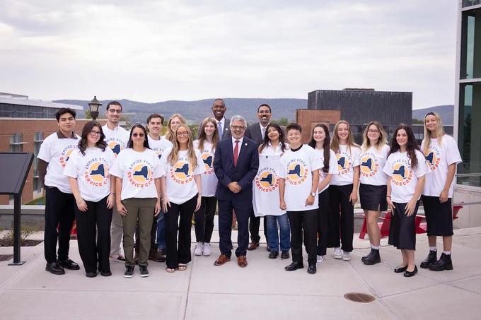 Chancellor King, Lt. Governor Delgado, and President Cardelle pose with SUNY Oneonta students