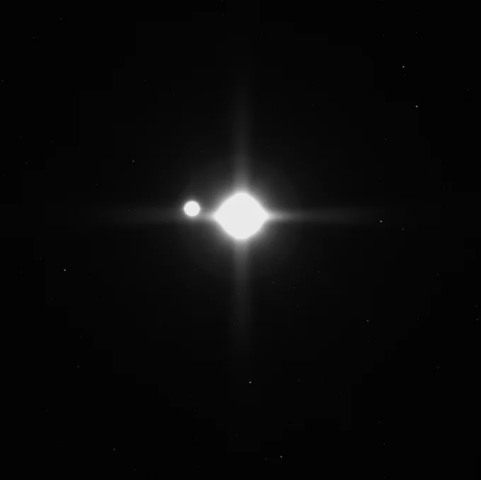 Same view, but much more saturated, of the Moon on the left and the Earth on the right. The two objects appear as two bright blobs of light. 