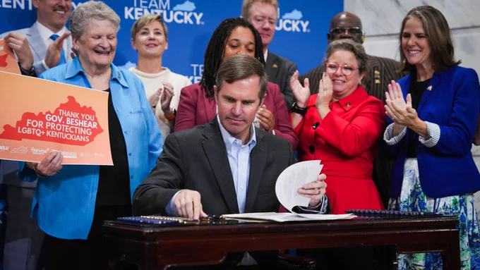 An image of Governor Beshear preparing to sign an executive order banning the practice of conversion therapy on minors in Kentucky.