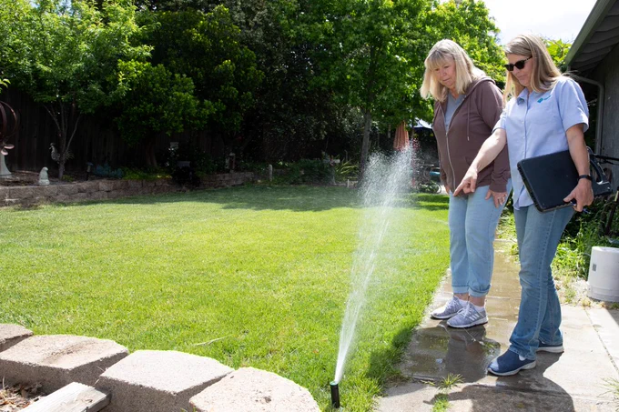 A CCWD Water Use Efficiency Technician with a customer in their backyard conducting a Water Wise House Call.