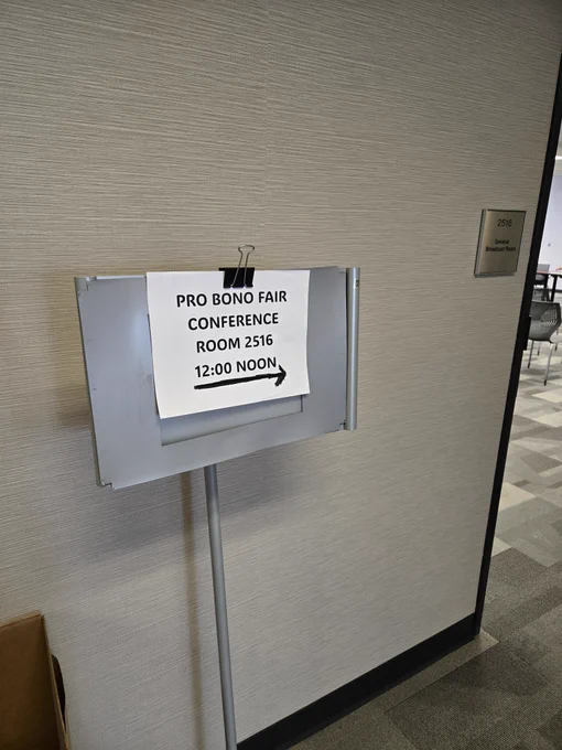 Sign reading "Pro Bono Fair" with arrow 