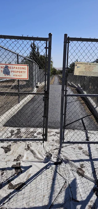a photo of a gated bike path with a "no trespassing" sign.