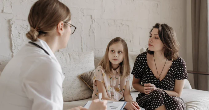 Doctor speaking with mother and daughter