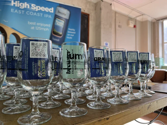 pictures of Gravity festival glasses, we can see a poster from our sponsor LUMO travel in the background