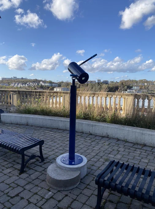 The Dream-O-Scope stands like a telescope in a public park aimed across a body of water.