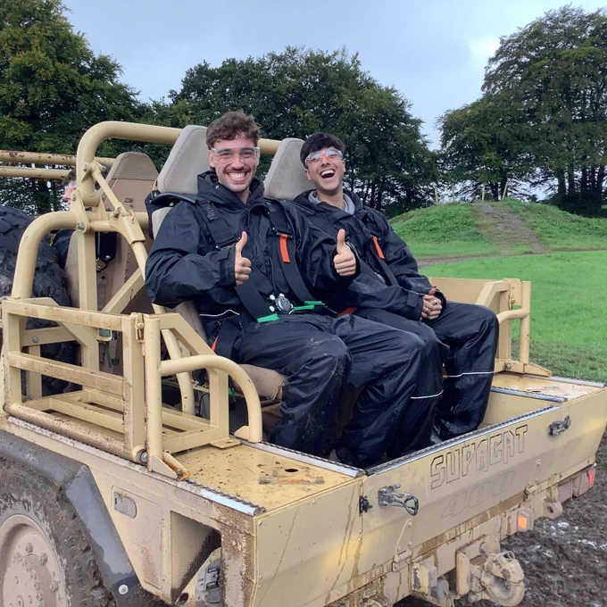 Two students smile in the back of a Supacat transporter