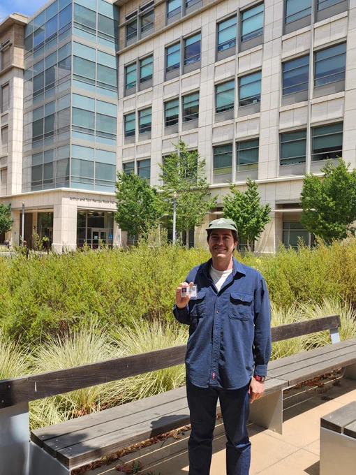 Me outside my lab building holding my UCSF badge