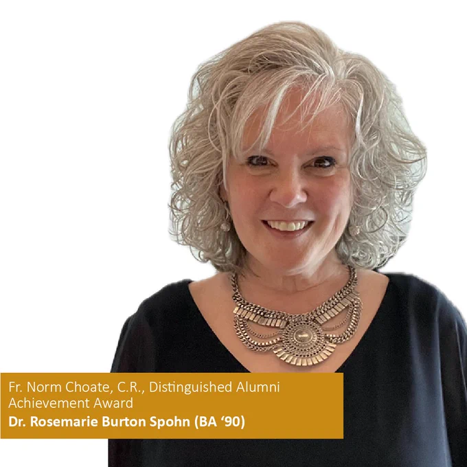 Dr. Rosemarie Burton Spohn (BA '90) smiling with curly gray hair wearing a statement necklace, text below indicates award recognition related to alumni achievement.