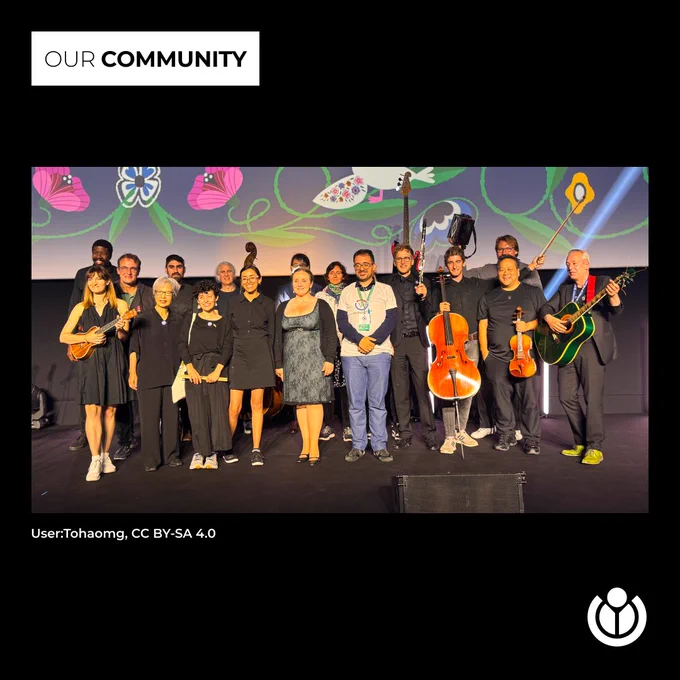 A diverse group of people holding instruments on stage at Wikimania 2024.